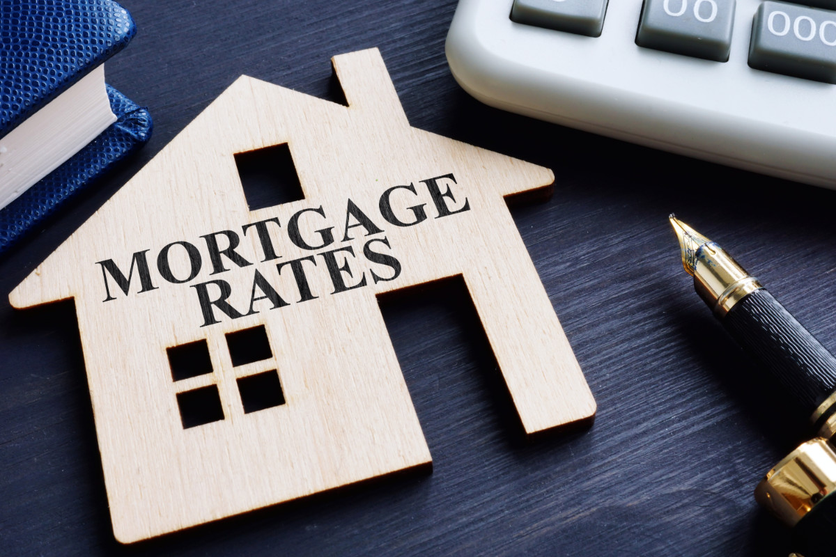 Mortgage rates written on a wooden model of house.
